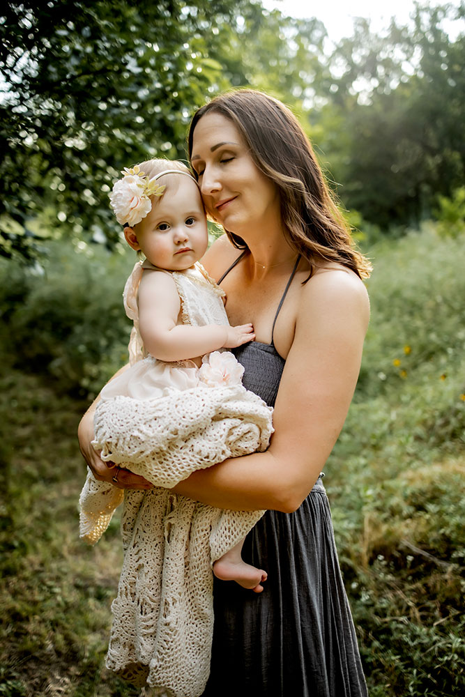 Mom and baby together at a first birthday photo session that also includes a cake smash session.