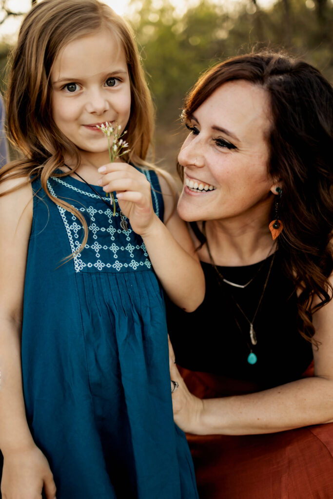 A mom embraces her daughter in the sunshine at a spring photo session at Lake Grapevine with Anna Roorda Photography.