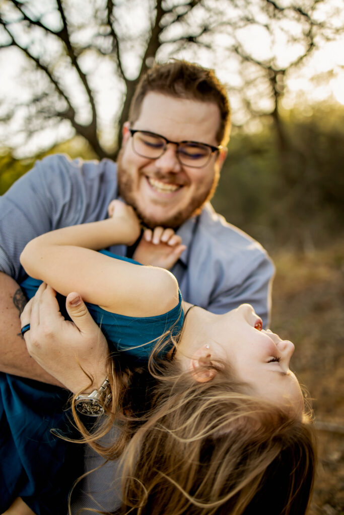 A dad plays with his daughter in the sunshine at a spring photo session at Lake Grapevine with Anna Roorda Photography.