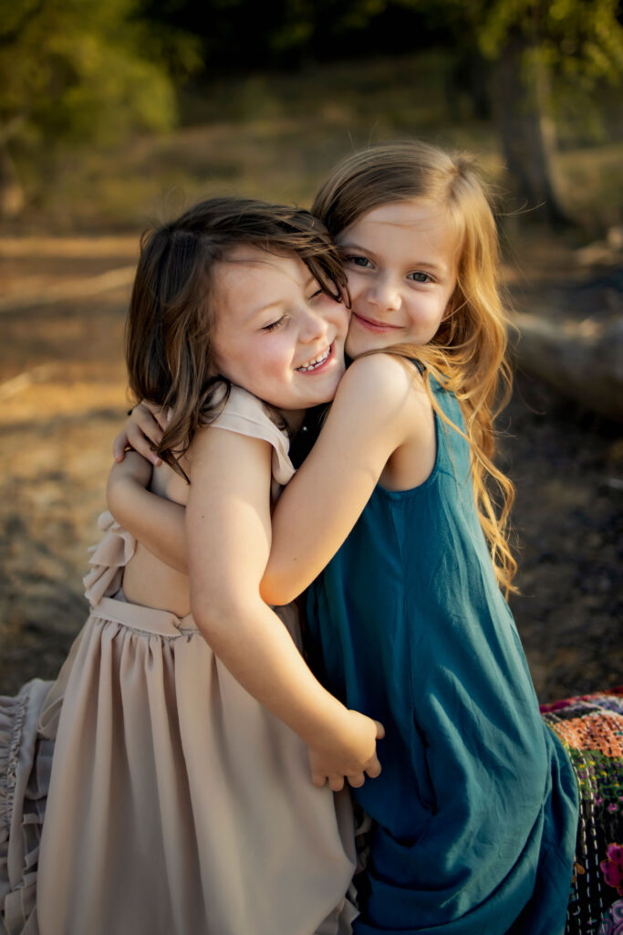 sisters play in the sunshine at a spring photo session at Lake Grapevine with Anna Roorda Photography.