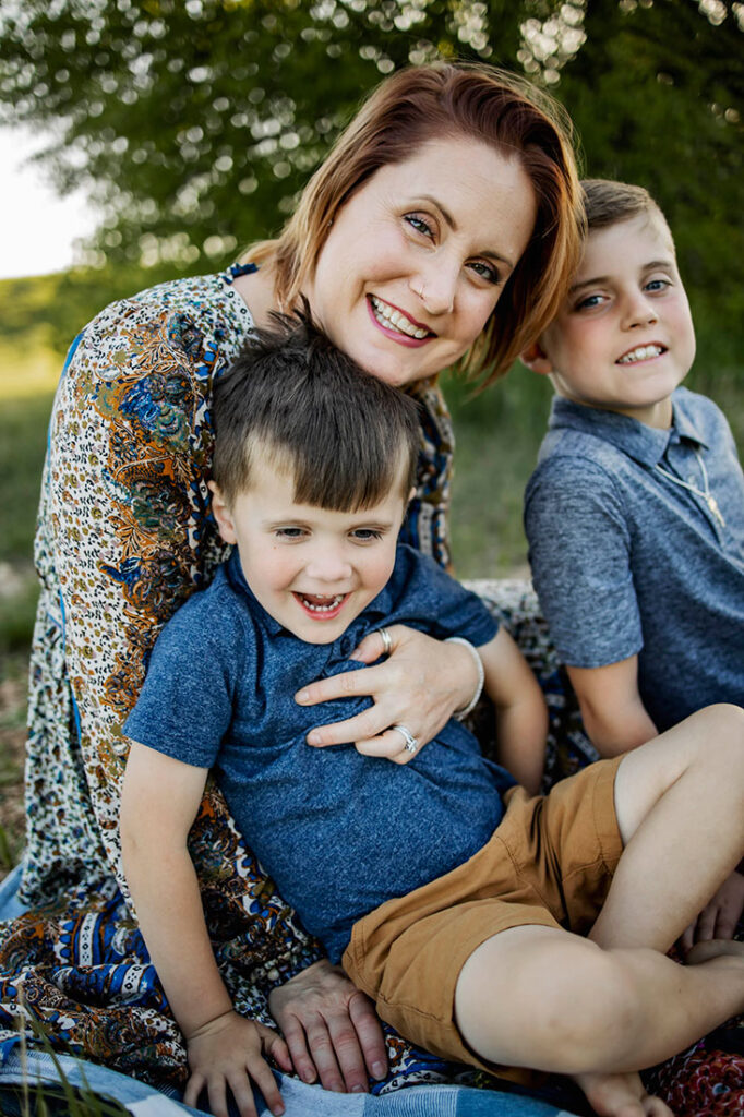 Two boys lean into mom and  play while at a session with Anna Roorda Photography in Plano, TX at arbor hills nature preserve.