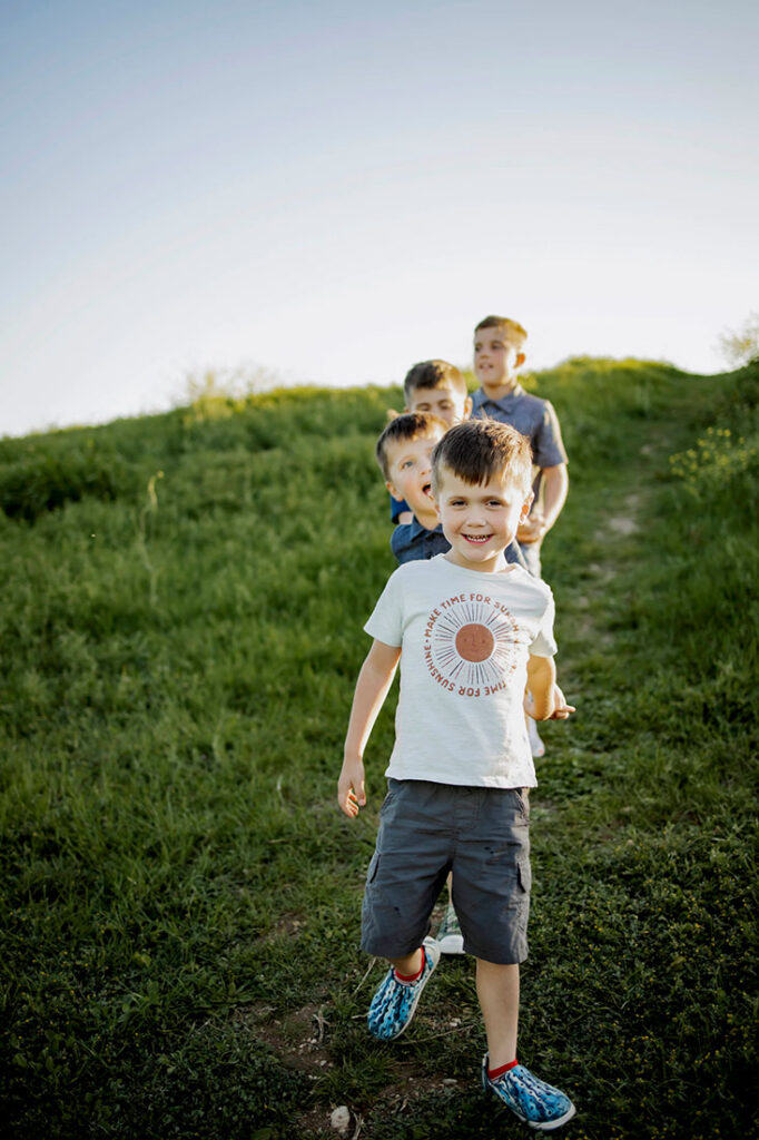 Four young sibling boys play while at a session with Anna Roorda Photography in Plano, TX at arbor hills nature preserve.
