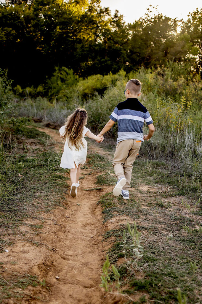 A brother and sister walk down a path in Southlake Texas at a Spring half session.