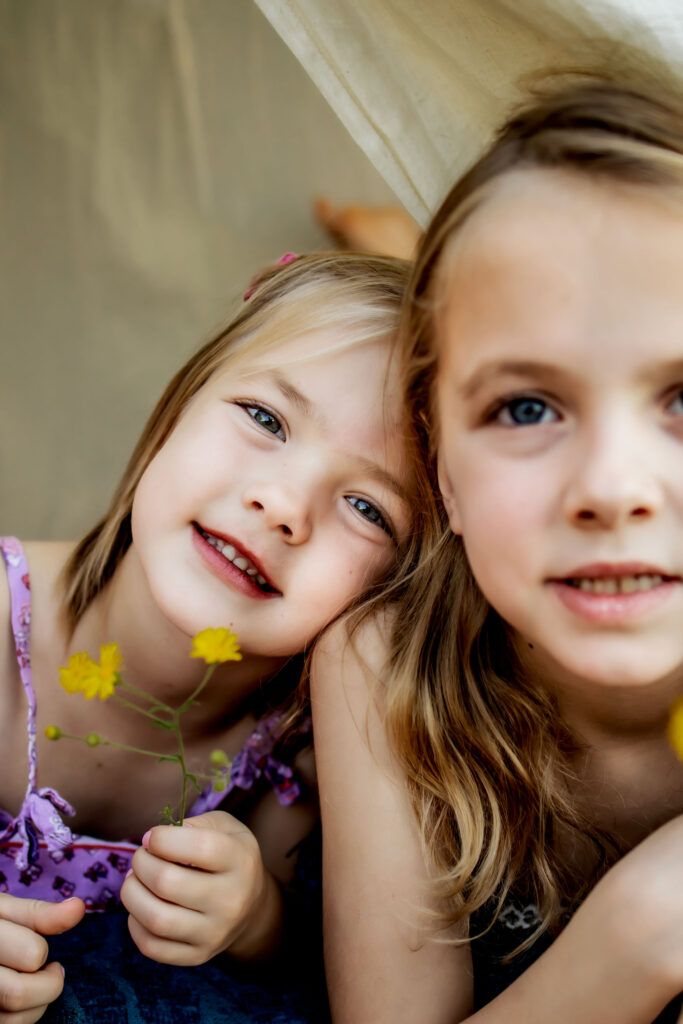 Two sisters in a tent in Flower mound, TX with wild flowers