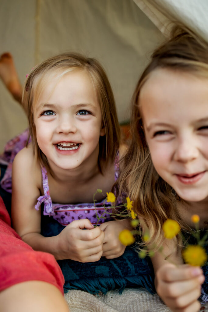 Two sisters in a tent in Flower mound, TX with wild flowers