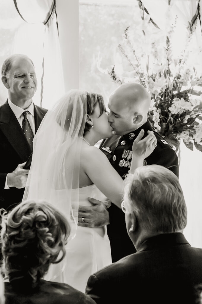 A bride and groom kiss at their wedding ceremony in Denton Texas.