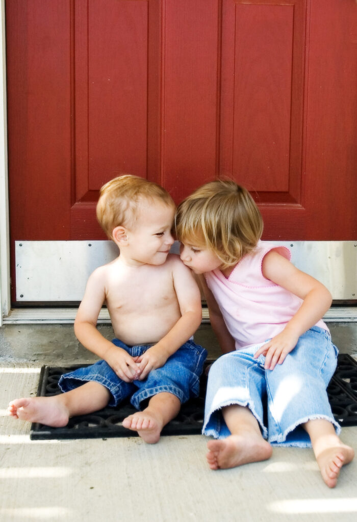 A brother and sister sitting on the porch of their North Dallas home.