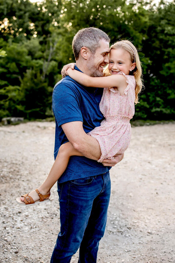 Dad hugs his daughter at a summer photo session in Plano, Texas