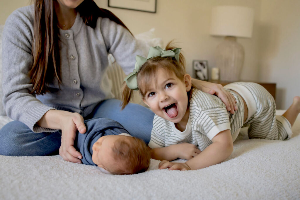 A mom with her newborn son and her toddler daughter at an in home lifestyle session.